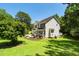 Exterior view of a two-story home with a small deck, mature trees, and landscaping at 1201 Teakwood Ct, Sanford, NC 27330