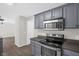 Updated kitchen showcasing stainless steel appliances, granite countertops and modern gray cabinetry at 1201 Teakwood Ct, Sanford, NC 27330