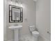 Chic half bathroom with sleek pedestal sink and contemporary square mirror and toilet at 125 Davis St, Louisburg, NC 27549
