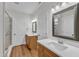 Bathroom featuring double vanities, wood-finished cabinets, white countertops, and vinyl flooring at 125 Davis St, Louisburg, NC 27549