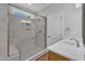 Modern bathroom features an enclosed shower with a bench and a wood-finished vanity at 125 Davis St, Louisburg, NC 27549