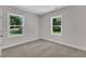 Bedroom showcasing carpet, two windows offering ample natural light, and neutral walls at 125 Davis St, Louisburg, NC 27549