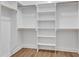 Large walk-in closet with wood floor and white shelves and railings at 125 Davis St, Louisburg, NC 27549