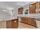 Bright kitchen featuring wooden cabinetry, stainless steel appliances, an island, and a view from the window at 125 Davis St, Louisburg, NC 27549