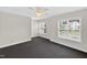 Large bright bedroom with dark gray carpet, ceiling fan, and three large windows offering plenty of natural light at 1437 Lindenberg Sq, Wake Forest, NC 27587