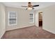 Carpeted bedroom with ceiling fan and two windows, providing ample natural light and a view to a bathroom at 1437 Lindenberg Sq, Wake Forest, NC 27587
