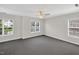 Bright bedroom with plush dark gray carpet, ceiling fan, and three large windows offering plenty of natural light at 1437 Lindenberg Sq, Wake Forest, NC 27587