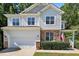 Attractive two-story home with stone accents, white siding, well-manicured landscaping, and an attached two-car garage at 1437 Lindenberg Sq, Wake Forest, NC 27587