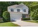 Charming two-story home features a stone facade, attached garage, and an inviting, landscaped front yard at 1437 Lindenberg Sq, Wake Forest, NC 27587