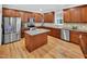 A well-lit kitchen with wood cabinets, stainless steel appliances, and center island provides ample workspace at 1437 Lindenberg Sq, Wake Forest, NC 27587