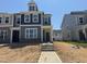 New two-story home featuring a modern exterior, large windows, and unfinished landscaping at 1559 Wendell Valley Blvd, Wendell, NC 27591