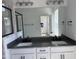Main bathroom with double sinks, gray counters, white cabinets and a tiled walk-in shower at 1563 Wendell Valley Blvd, Wendell, NC 27591