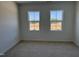 Carpeted bedroom featuring two windows with view to the construction site at 1563 Wendell Valley Blvd, Wendell, NC 27591