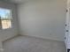 A bright carpeted bedroom featuring a window with view to the construction site at 1563 Wendell Valley Blvd, Wendell, NC 27591