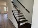 Staircase with dark wood steps and white risers lead to the upper level of the house at 1563 Wendell Valley Blvd, Wendell, NC 27591