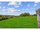 Expansive backyard featuring lush green grass and mature trees under a bright sky at 174 Arrow Ln, Middlesex, NC 27557