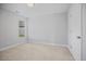 Clean, carpeted bedroom featuring a door and window offering ample natural light at 174 Arrow Ln, Middlesex, NC 27557