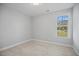 Bright bedroom with neutral carpet, walls, and natural light from the large window at 174 Arrow Ln, Middlesex, NC 27557