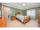 Cozy bedroom with green walls, wood furniture, and a comfortable bed with patterned linens at 1822 Atterbury Ln, Durham, NC 27712
