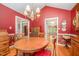 Formal dining room showcases a beautiful chandelier and striking red walls at 1822 Atterbury Ln, Durham, NC 27712