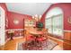 Formal dining room showcases a beautiful chandelier, a large arched window, and striking red walls at 1822 Atterbury Ln, Durham, NC 27712