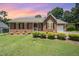 Beautiful brick home with a picturesque sunset backdrop, highlighting the manicured lawn and landscaping at 1822 Atterbury Ln, Durham, NC 27712