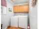Bright laundry room features wood cabinets, a window, and essential appliances at 1822 Atterbury Ln, Durham, NC 27712