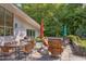 Charming backyard with stone patio, outdoor dining set, grill, and lush greenery, great for entertaining at 1908 S Lakeshore Dr, Chapel Hill, NC 27514