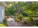 Inviting backyard with mature trees, green lawn, patio, and lush garden perfect for relaxation at 1908 S Lakeshore Dr, Chapel Hill, NC 27514