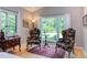 Charming bedroom seating area with patterned chairs, antique desk, and scenic views from large windows at 1908 S Lakeshore Dr, Chapel Hill, NC 27514