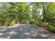 Gravel driveway surrounded by lush landscaping and mature trees at 1908 S Lakeshore Dr, Chapel Hill, NC 27514