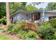 Modern home featuring a landscaped yard, outdoor seating, and wooded backdrop at 1908 S Lakeshore Dr, Chapel Hill, NC 27514