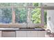 Modern kitchen sink is set beneath a large window offering views of the outdoor greenery at 1908 S Lakeshore Dr, Chapel Hill, NC 27514