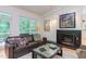 Comfortable living room with brown leather sofa, fireplace, and art, offering a cozy ambiance at 1908 S Lakeshore Dr, Chapel Hill, NC 27514