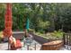 Inviting outdoor patio with comfortable seating, hot tub, and lush landscaping at 1908 S Lakeshore Dr, Chapel Hill, NC 27514