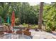 Beautiful backyard patio featuring stone pavers, outdoor seating, and wooded views at 1908 S Lakeshore Dr, Chapel Hill, NC 27514