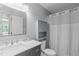 Bright bathroom with a white shower curtain, gray vanity with marble countertop, and ample storage space at 208 Silk Hope Dr, Cary, NC 27519