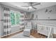 Charming Bedroom with gray walls, white crib, comfortable chair, and ample natural light from the nearby window at 208 Silk Hope Dr, Cary, NC 27519