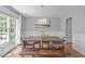 Sunlit dining room with hardwood floors, wainscoting, modern chandelier, and elegant decor provides a comfortable setting at 208 Silk Hope Dr, Cary, NC 27519