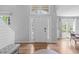 Bright foyer featuring hardwood floors, side lights, transom window, and high ceilings, creating an inviting entry at 208 Silk Hope Dr, Cary, NC 27519