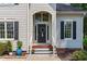 Inviting front entrance with decorative wreath, potted plants, and classic architectural details and front yard at 208 Silk Hope Dr, Cary, NC 27519
