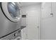 Efficient laundry area featuring a stacked washer and dryer with utility storage at 208 Silk Hope Dr, Cary, NC 27519