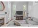 Inviting living room with a fireplace, large windows, and comfortable seating offers a relaxing space at 208 Silk Hope Dr, Cary, NC 27519