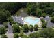Aerial view of a community pool with ample seating surrounded by lush landscaping and trees at 208 Silk Hope Dr, Cary, NC 27519
