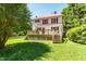 Expansive backyard with a large deck, lush lawn, and mature trees, creating a serene outdoor space at 210 Peachtree St, Roxboro, NC 27573