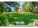 Expansive backyard view featuring a two-story home with red roof and a covered back porch and lawn at 210 Peachtree St, Roxboro, NC 27573