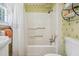 Bright bathroom features a shower-tub combination with floral wallpaper at 210 Peachtree St, Roxboro, NC 27573