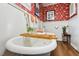 Quaint bathroom features a clawfoot tub and elegant red floral wallpaper at 210 Peachtree St, Roxboro, NC 27573