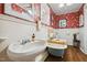 Charming bathroom showcasing a vintage sink, clawfoot tub, and red floral wallpaper at 210 Peachtree St, Roxboro, NC 27573