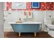 Vintage bathroom features a unique clawfoot tub and floral wallpaper at 210 Peachtree St, Roxboro, NC 27573